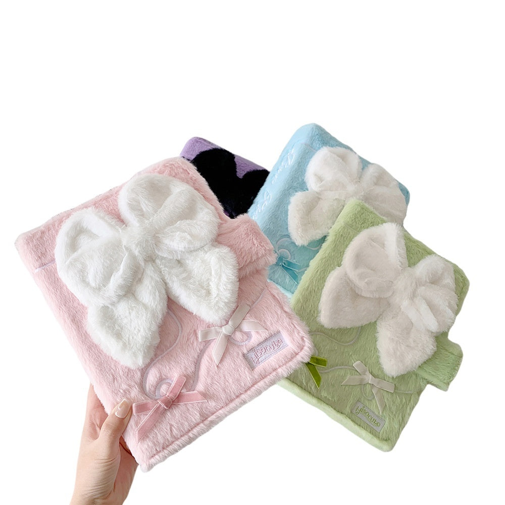 Three soft cloths with butterfly designs in pink, blue, and green held by a hand on a white background.